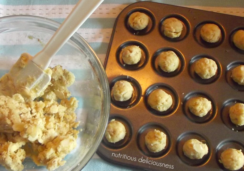 Baking tray with unbaked cookie dough with a glass bowl with cookie dough.