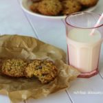Cookies on a white plate with a glass of milk in a pink glass with a straw