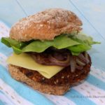 Burger in a bun with cheese, onions and lettuce