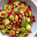 brussels sprouts roasted with pomegranate seeds in white bowl