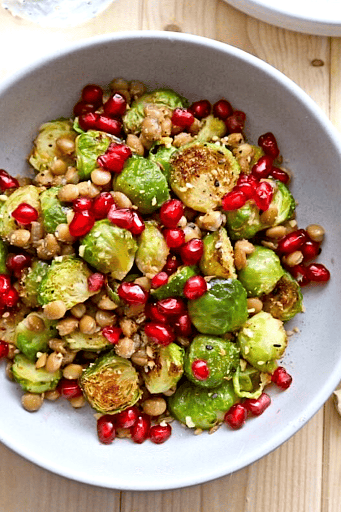 brussels sprouts roasted with pomegranate seeds in white bowl