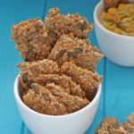 4 seed crackers on a wooden board.