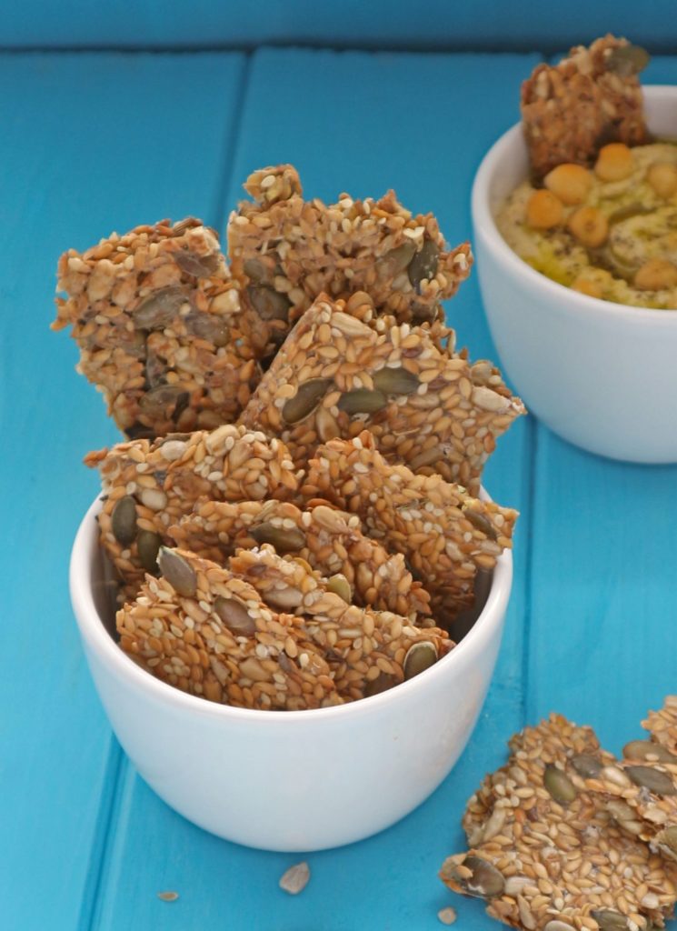 4 seed crackers on a wooden board.