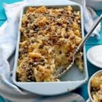 Roasted Cauliflower Mac and Cheese in blue pan with serving spoon and some missing