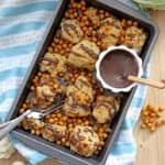 Roasted Cauliflower with Chickpeas on baking sheet and Tahini Pomegranate Dressing on side