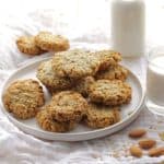 Vegan Almond Milk Flaxseed Oat Cookies on white plate with milk in bottle in background