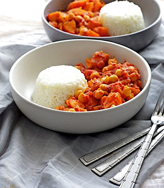 sweet potato curry with rice in bowl and forks on side
