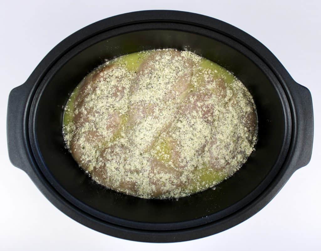 chicken breasts in chicken broth with ranch seasoning in slow cooker