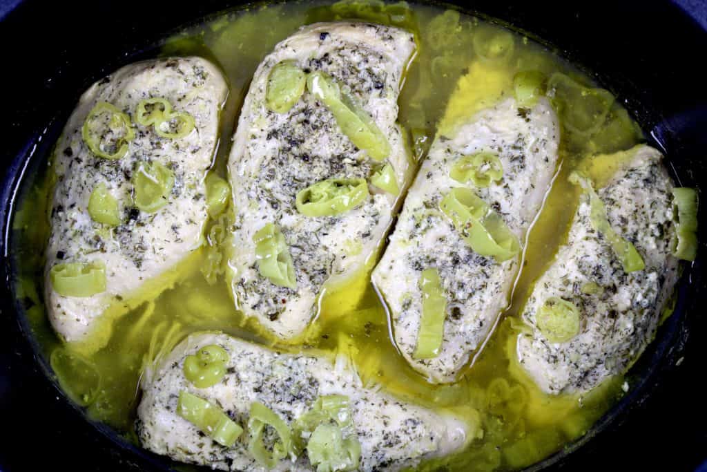 cooked Mississippi chicken breasts with sliced peppers in slow cooker