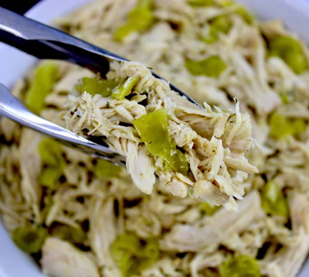 Mississippi chicken and pepper slices held up by tongs