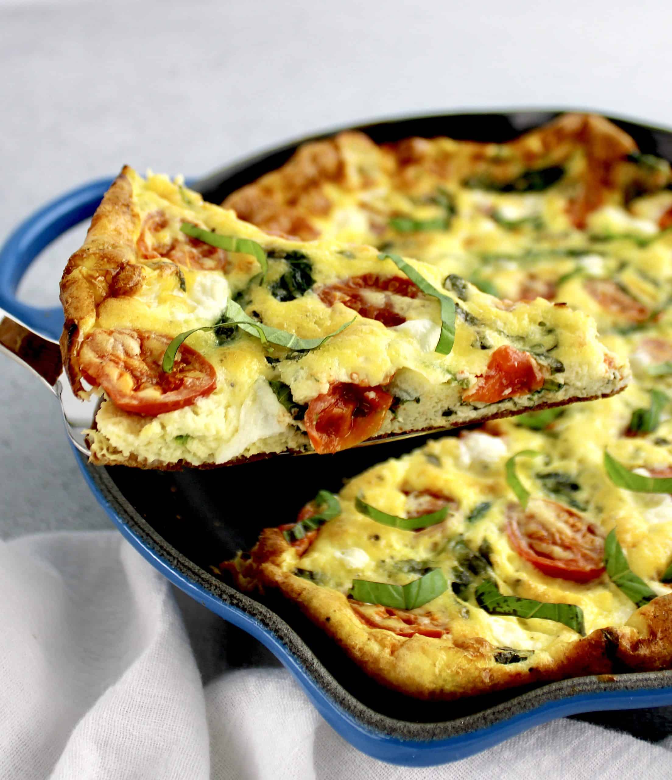 Caprese Frittata with slice being held up