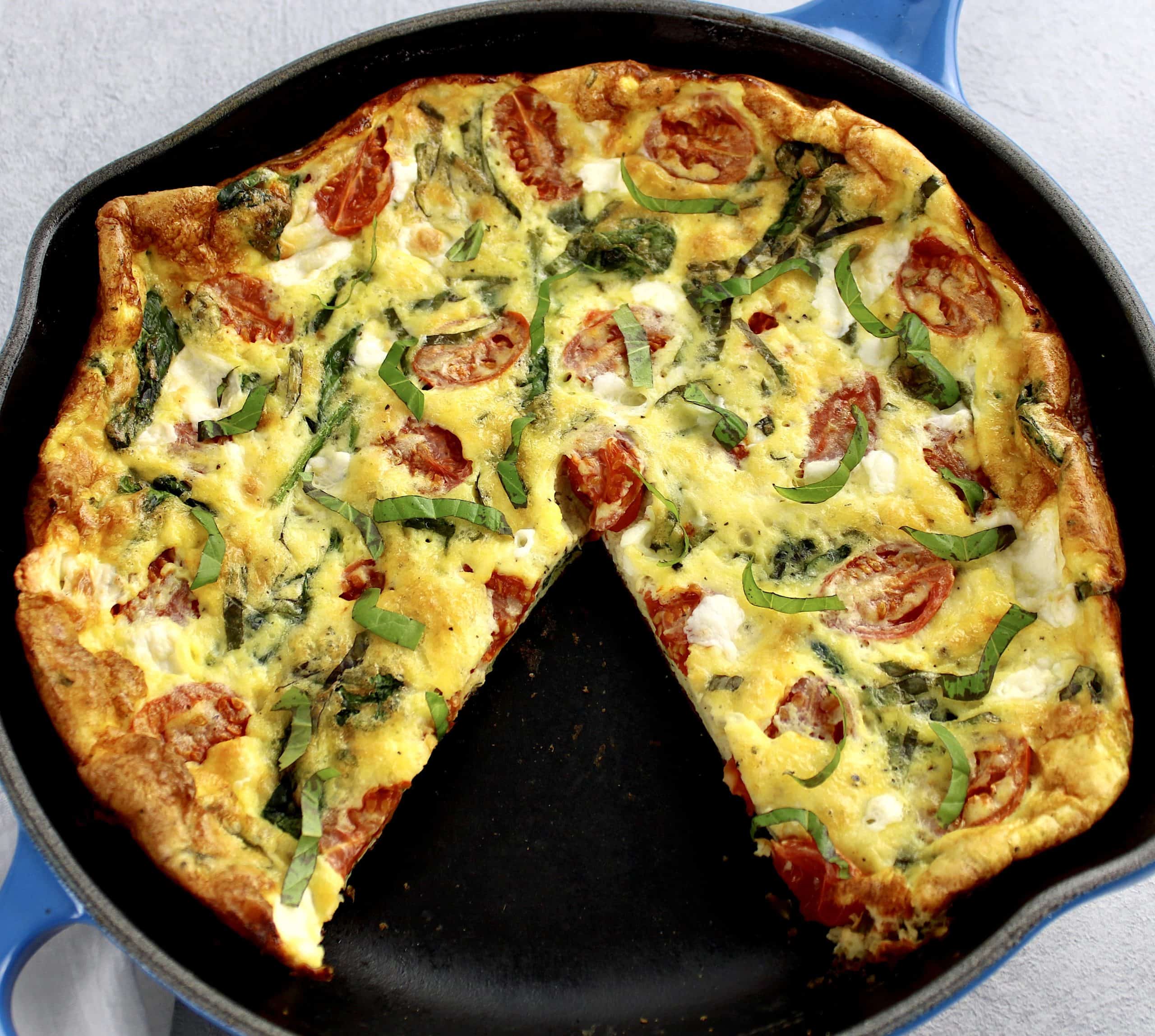 caprese frittata in skillet with slice taken out