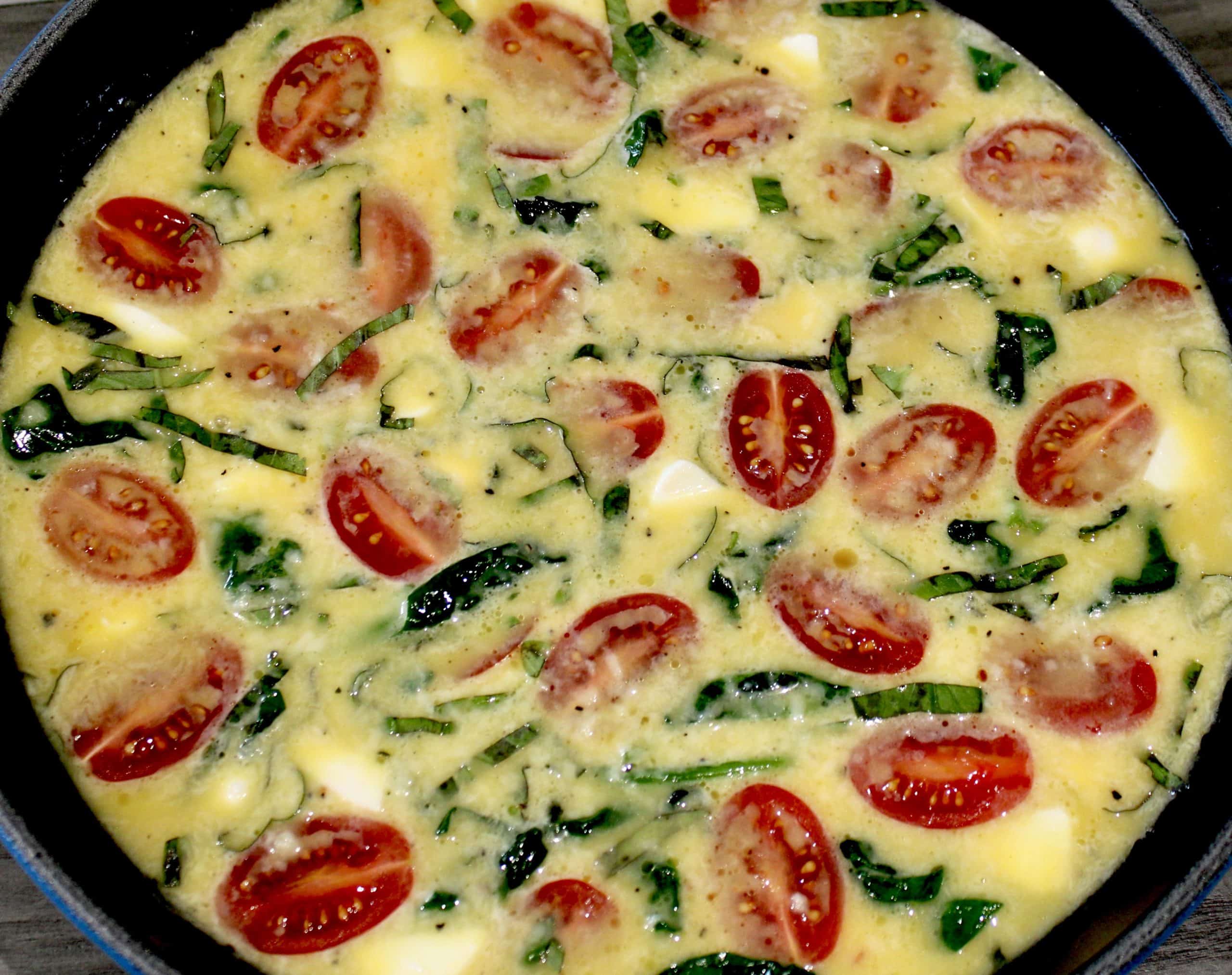 caprese frittata uncooked in skillet