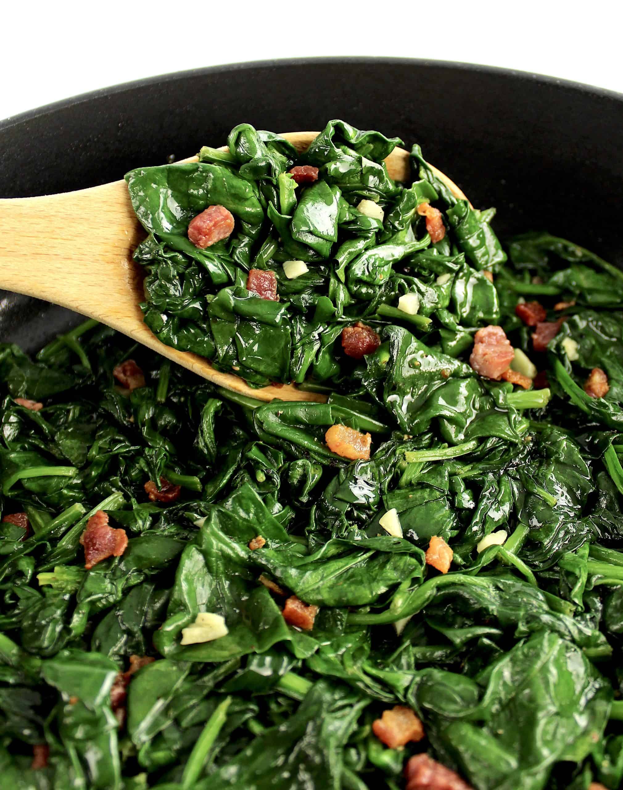 Sautéed Spinach with Pancetta with wooden spoon holding up some