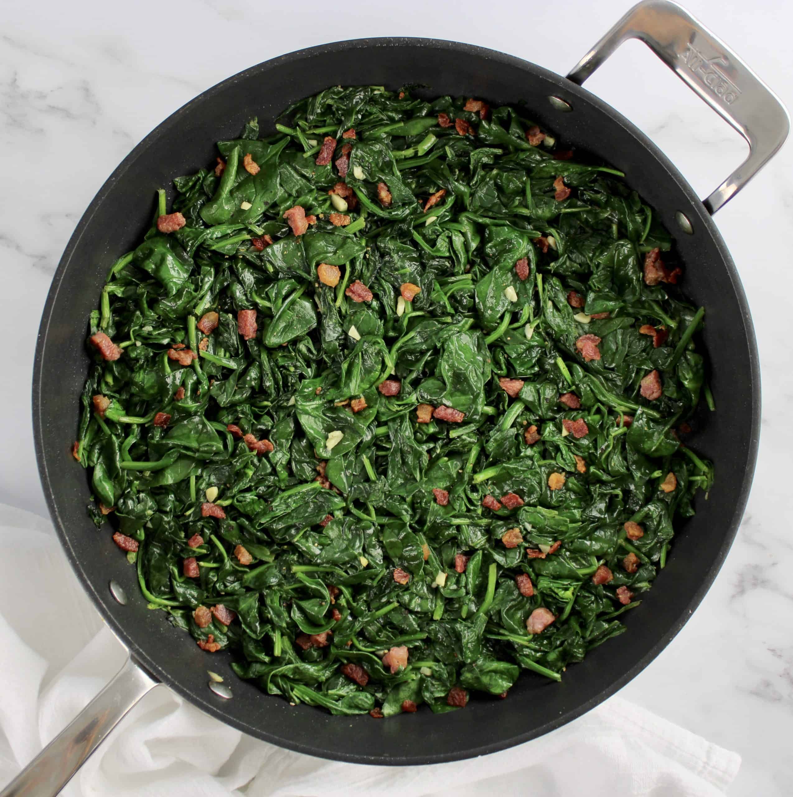 overhead view of Sautéed Spinach with Pancetta in skillet