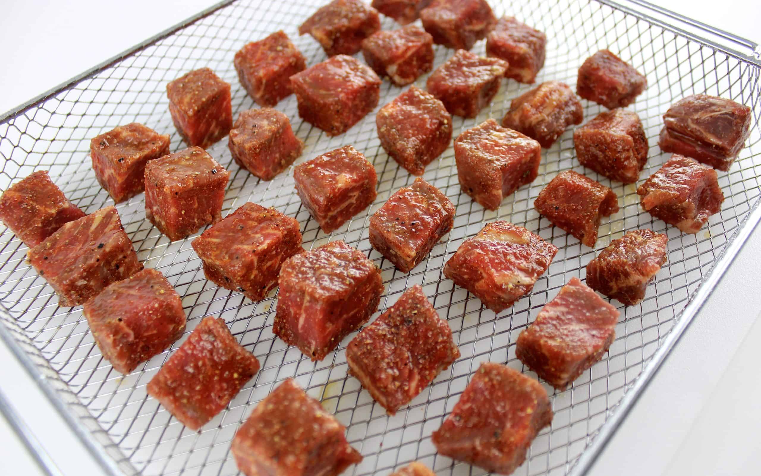steak bites uncooked on air fryer rack