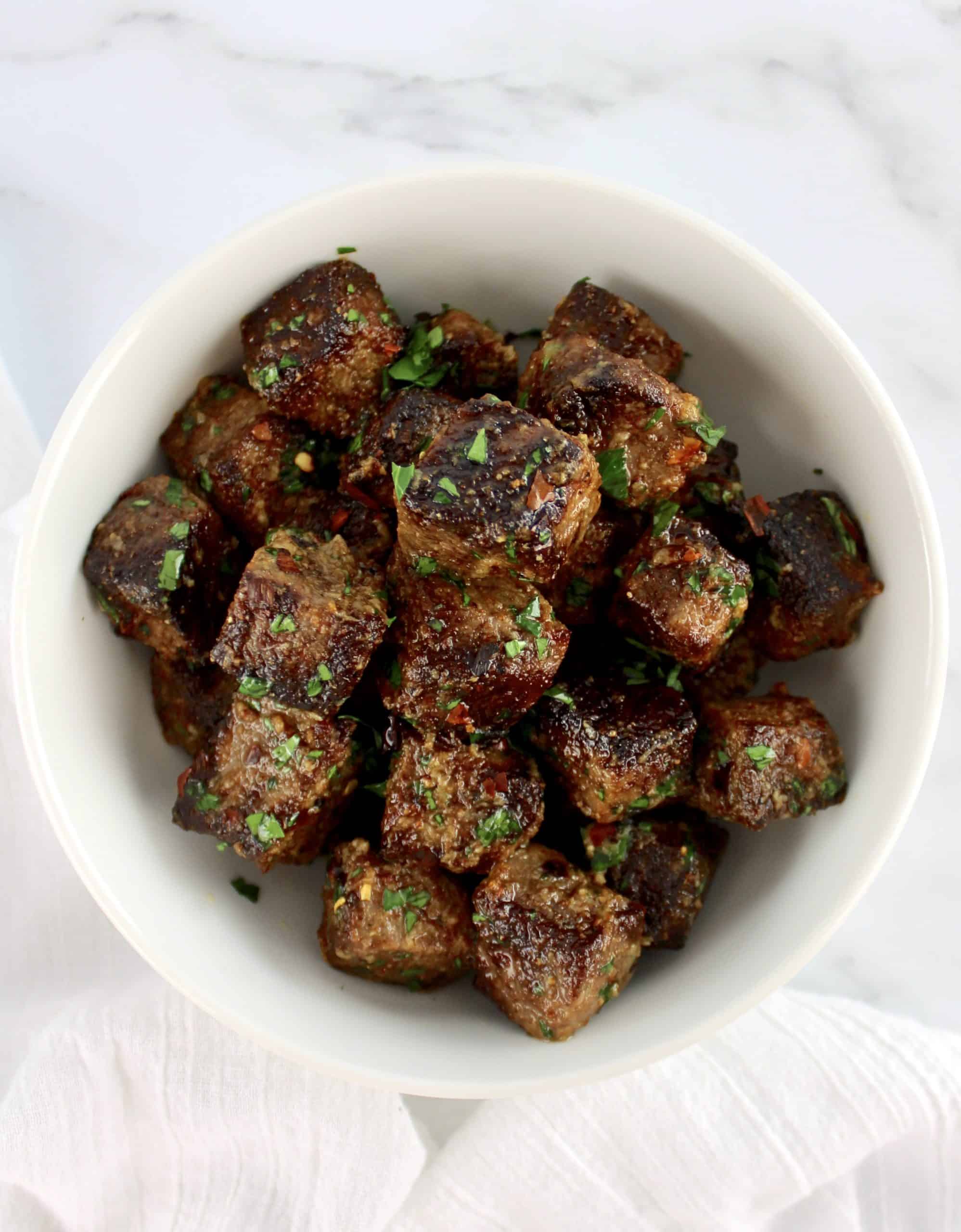 overhead view of Air Fryer Steak Bites in white bowl