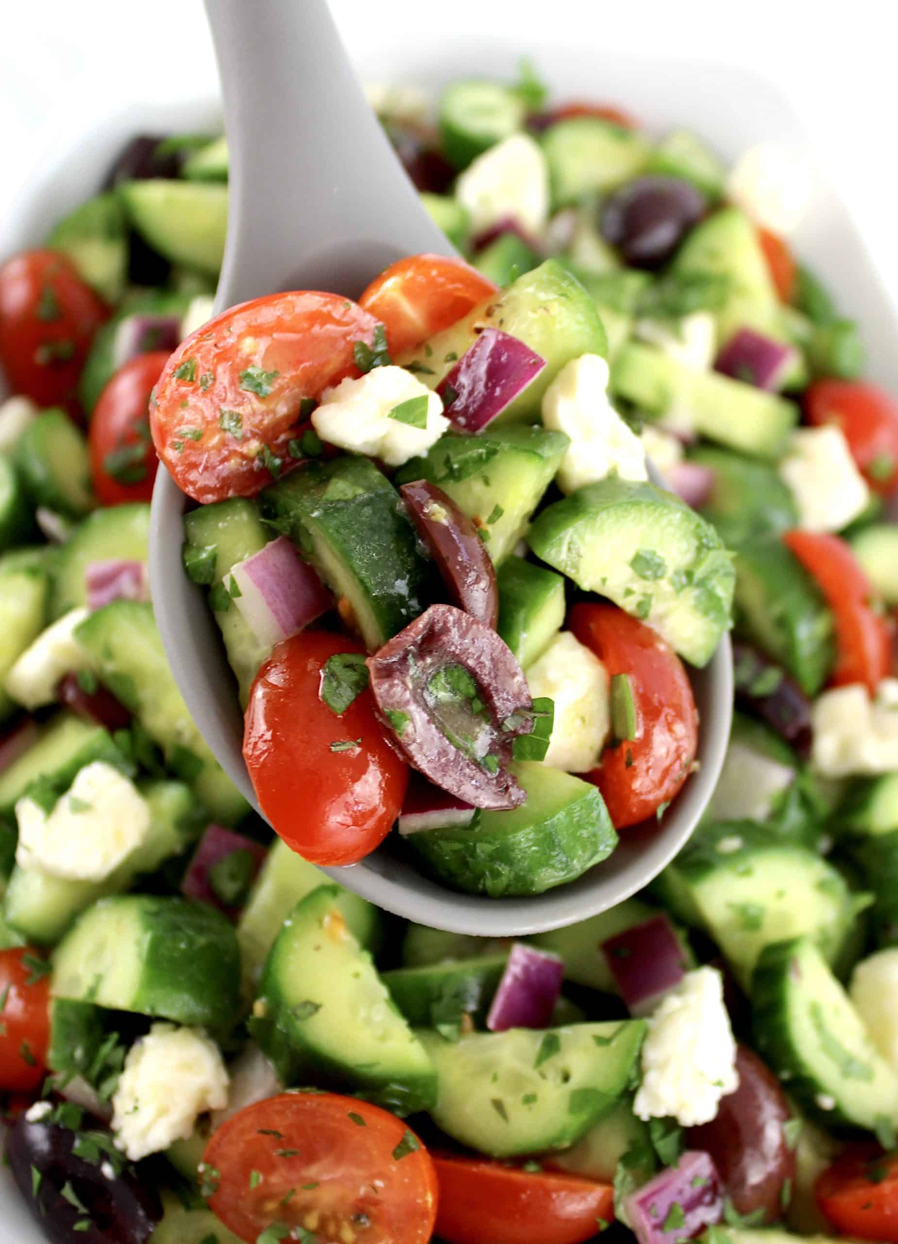 Mediterranean Cucumber Salad being spooned out of bowl
