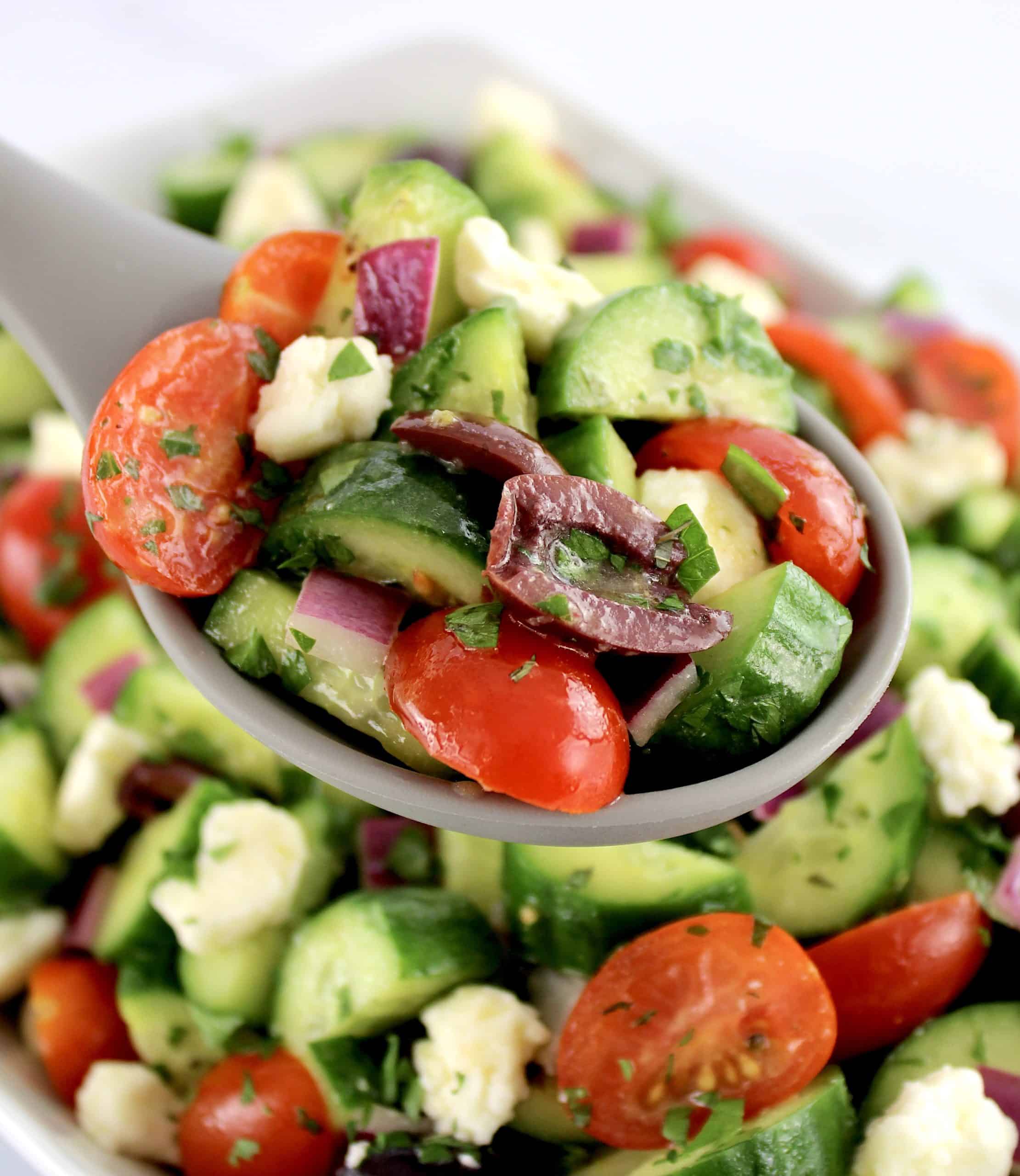 spoonful of Mediterranean Cucumber Salad with chopped parsley on top