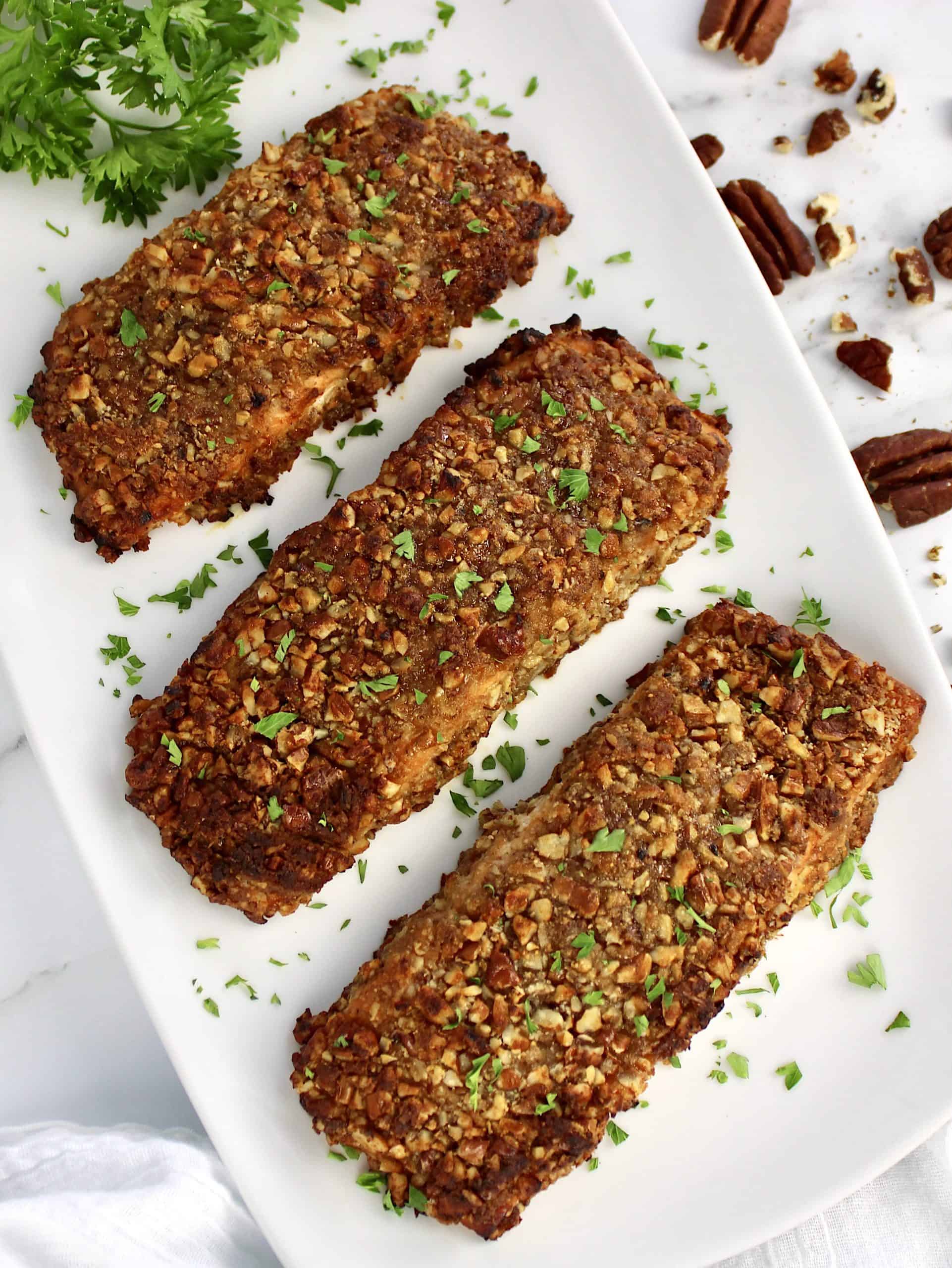 3 pieces Pecan Crusted Salmon on white platter