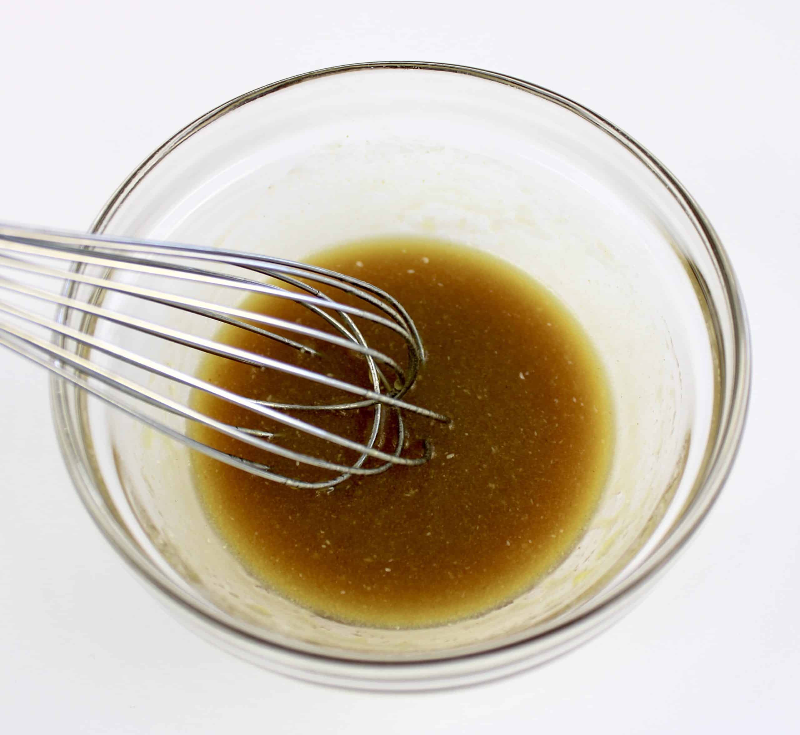 maple syrup mixture in glass bowl with whisk