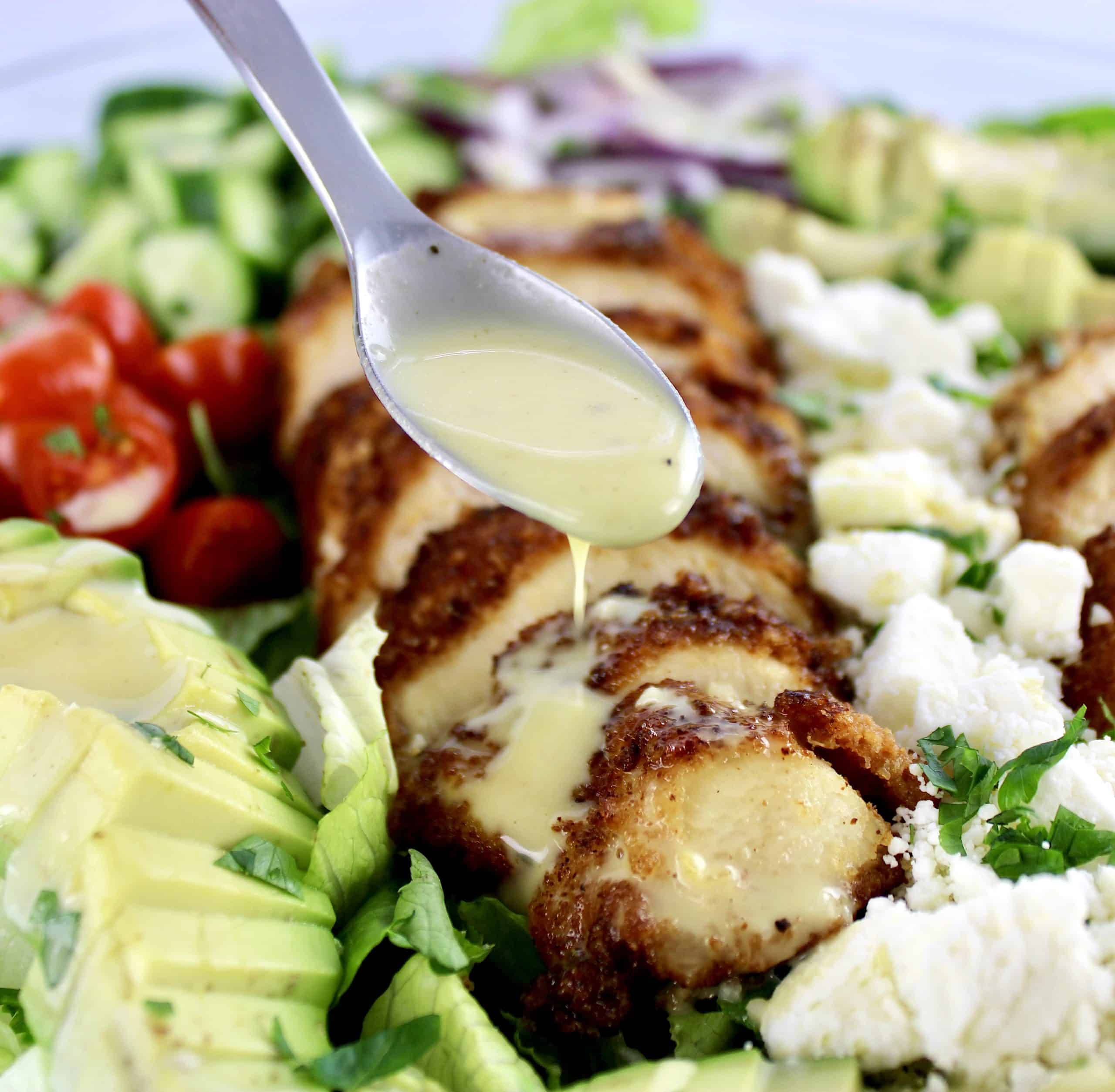 Crispy Chicken Salad with honey mustard dressing being spooned over top