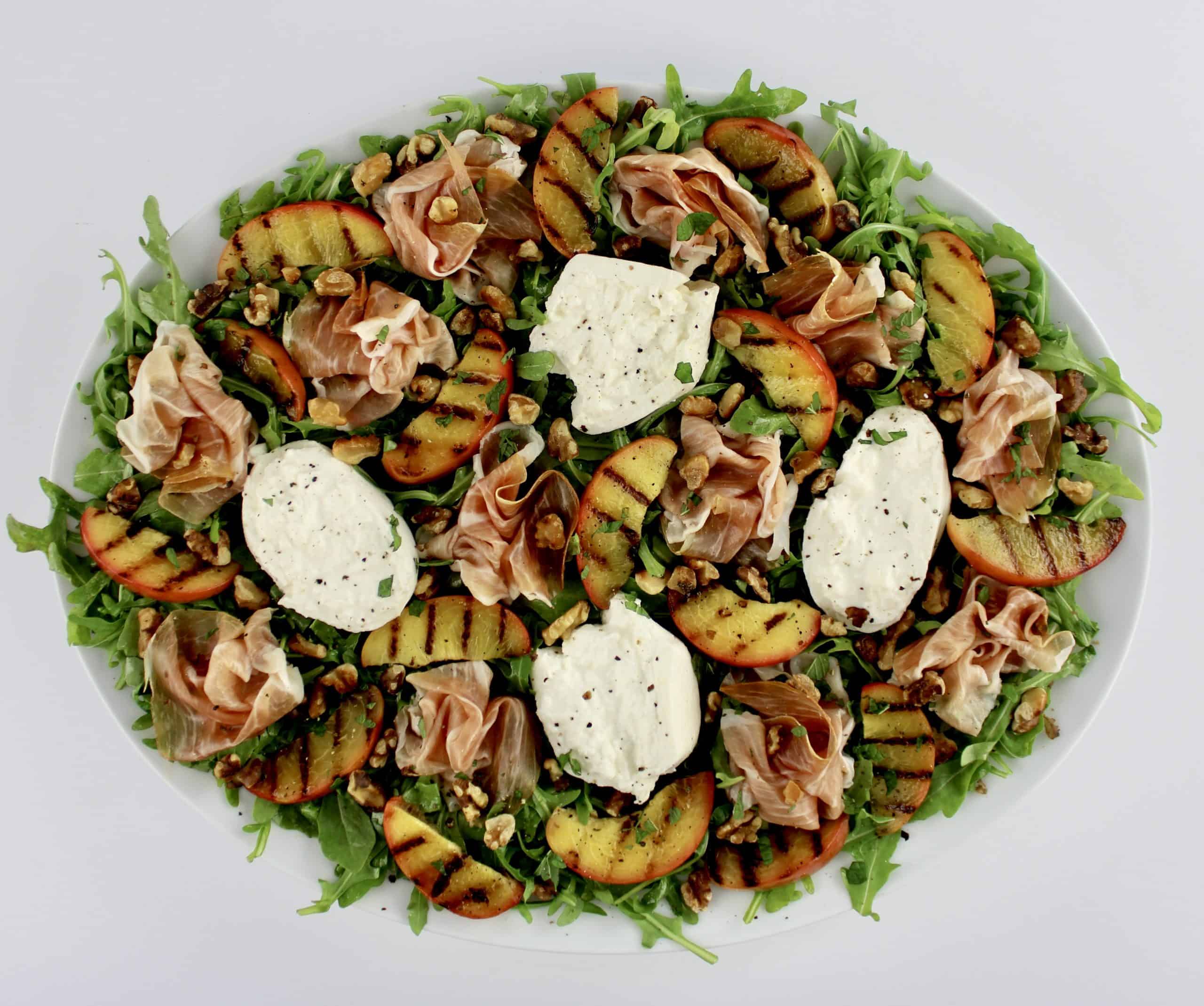 Grilled Peach Burrata Salad with Prosciutto on white platter
