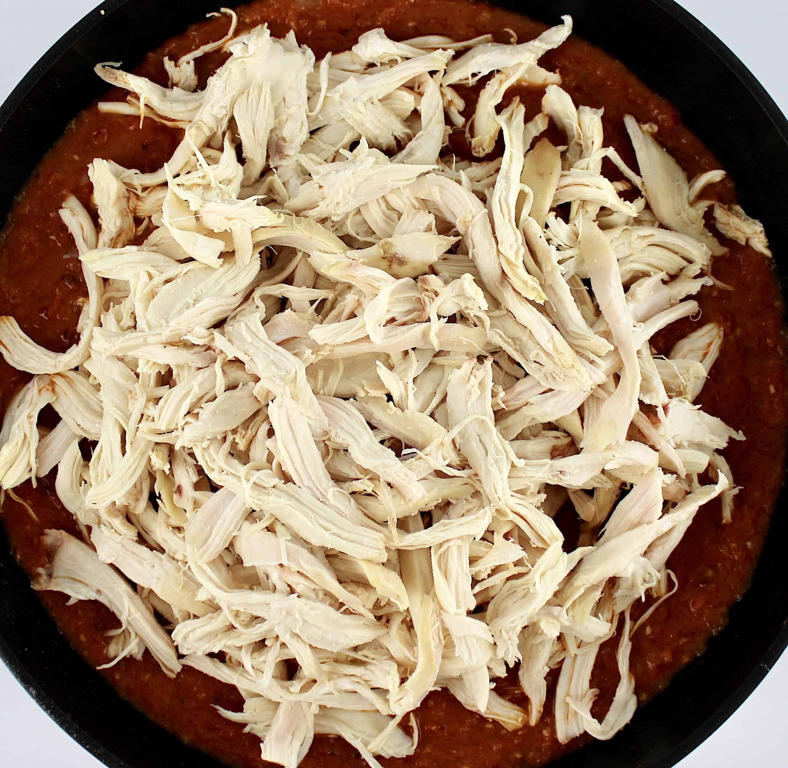 shredded chicken in chicken tinga sauce in skillet unmixed