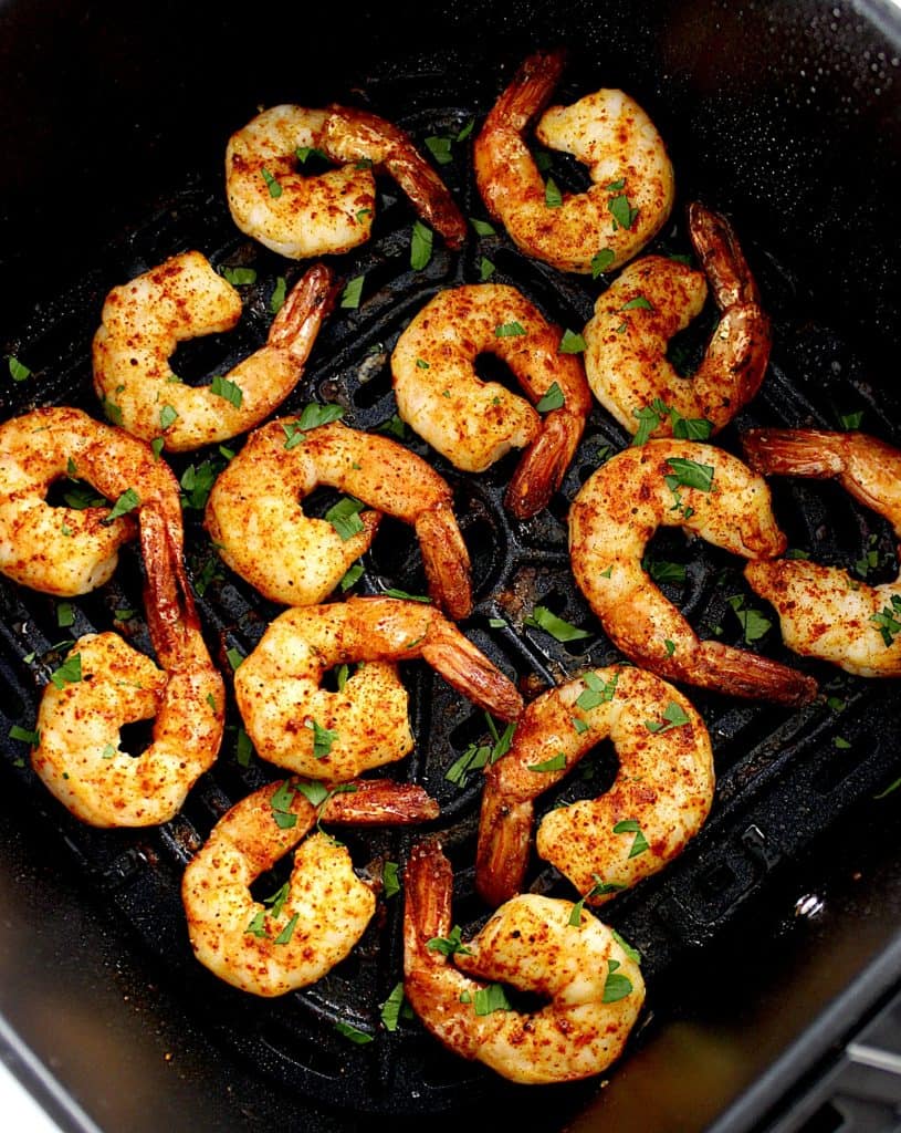 Air Fryer Frozen Shrimp in air fryer basket with chopped parsley