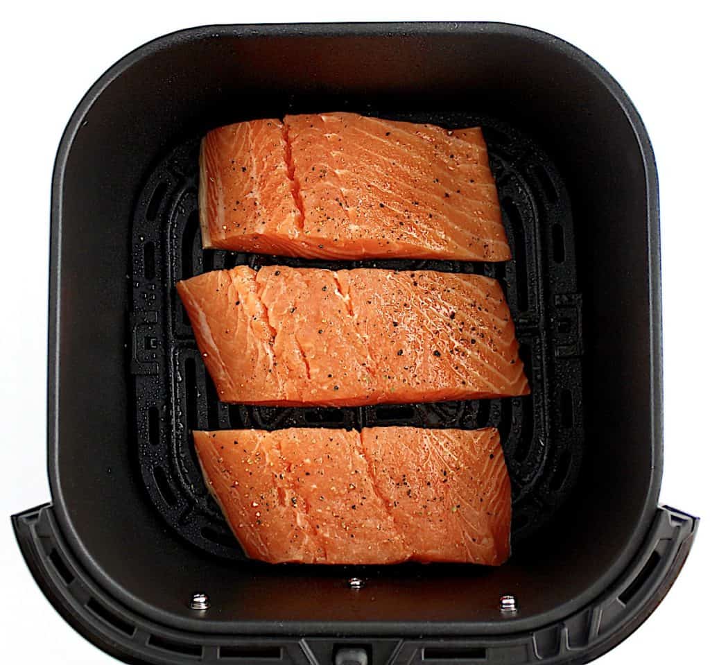 3 pieces of raw salmon in air fryer basket