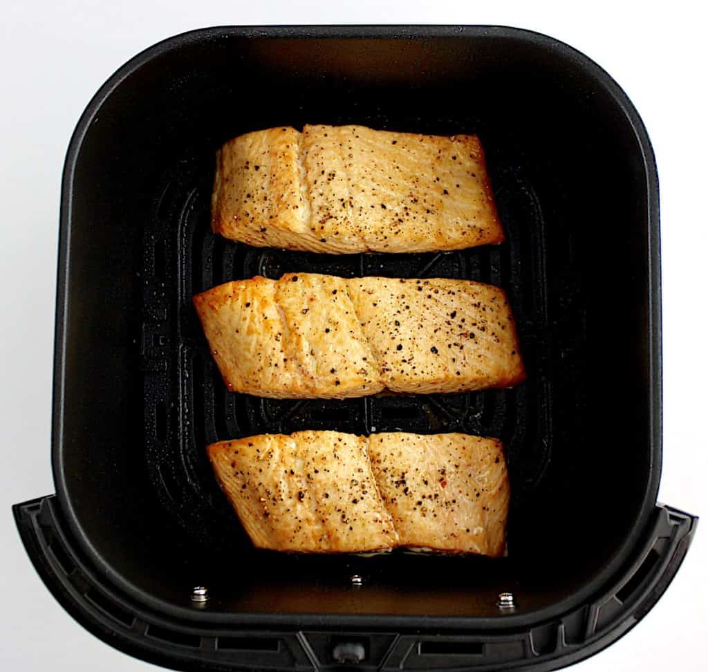 3 pieces of cooked salmon in air fryer basket