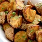 roasted potatoes inn white bowl with chopped parsley