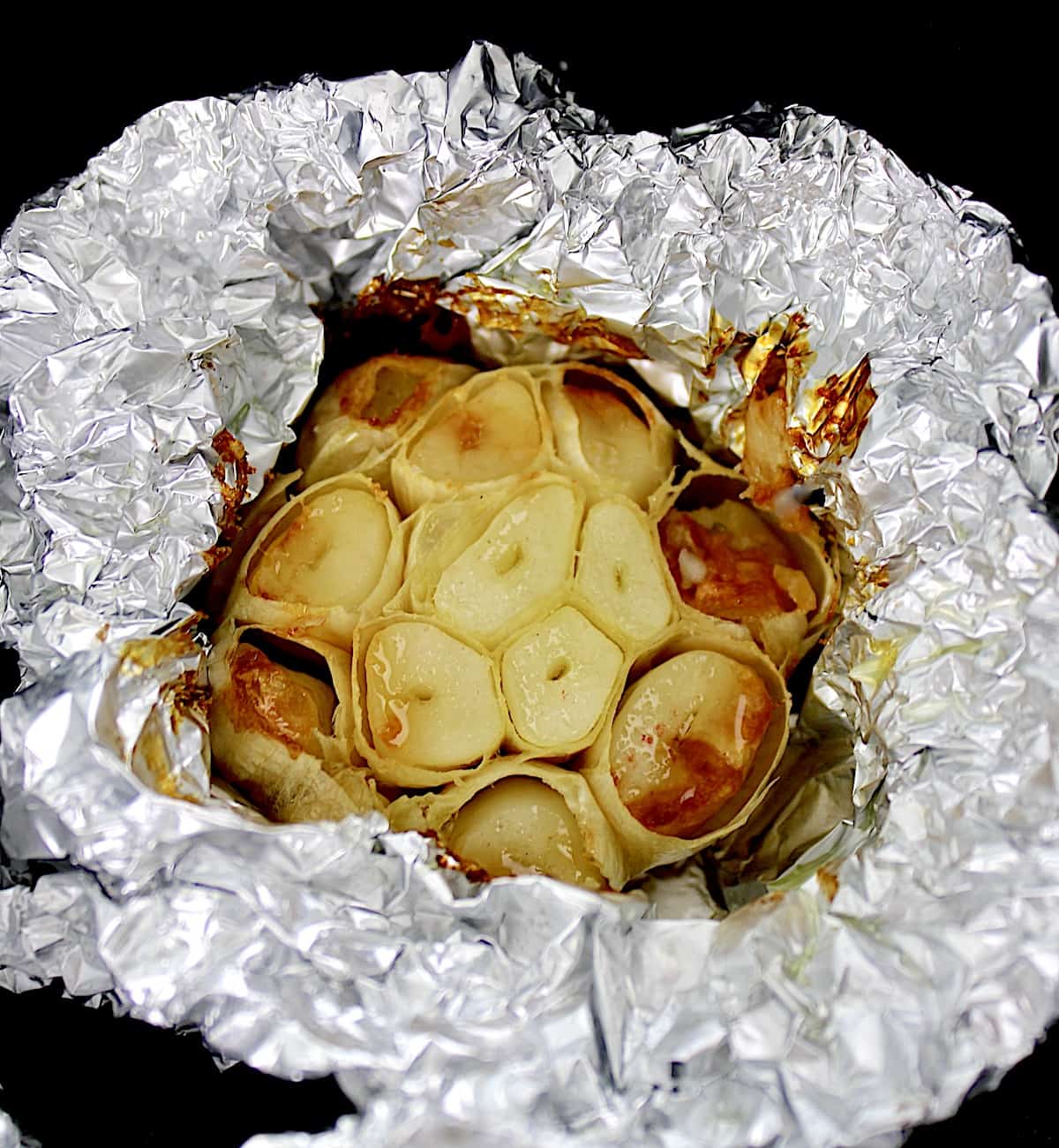 closeup of Air Fryer Roasted Garlic head in foil