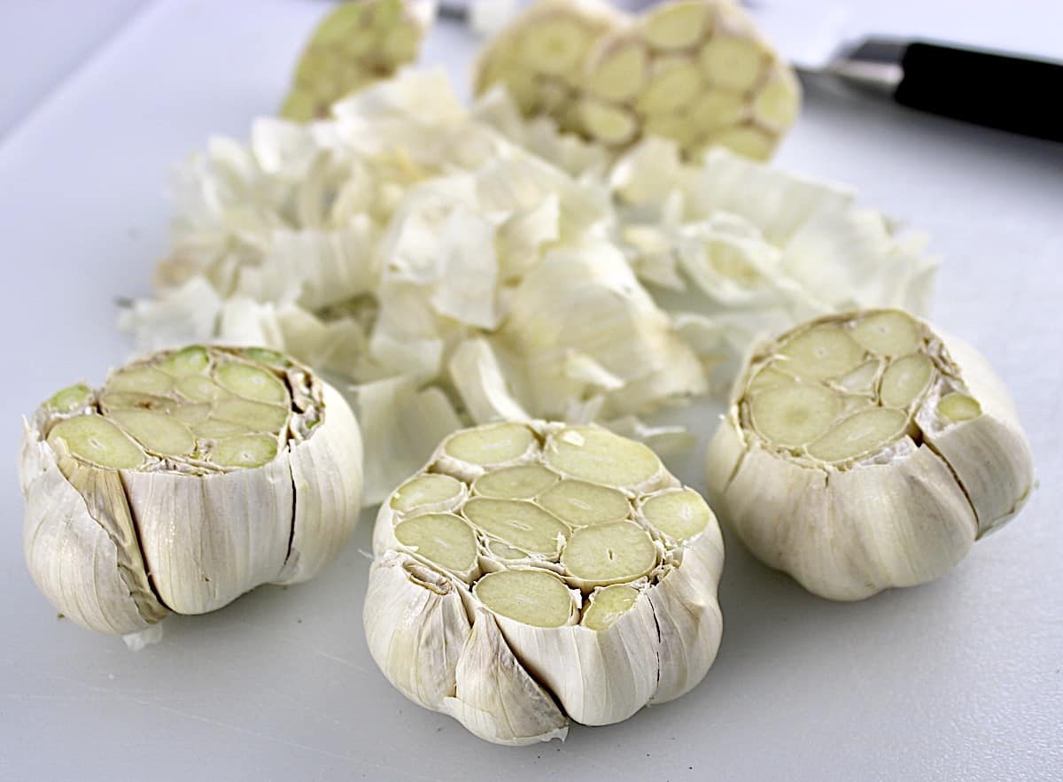 3 cut heads of garlic with extra paper in background