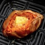 closeup of sweet potato in air fryer with butter