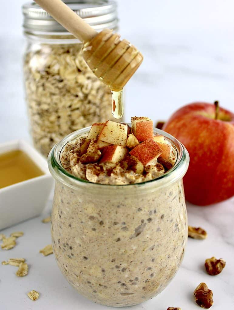 Apple Cinnamon Overnight Oats with honey being drizzled on top