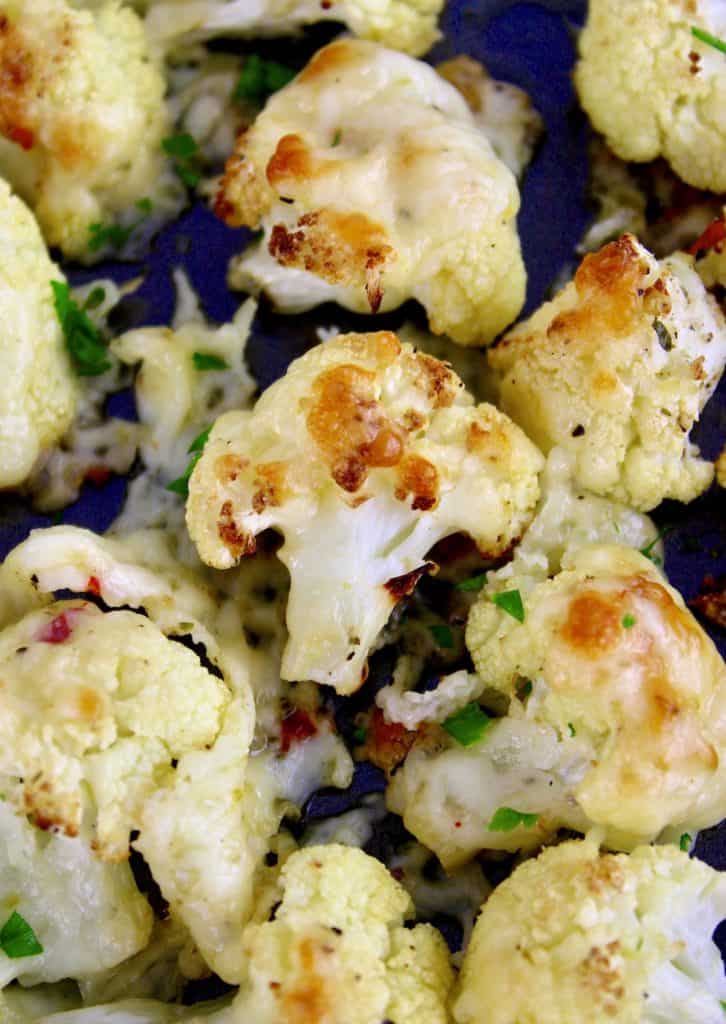 Cheesy Roasted Cauliflower closeup on sheet pan with chopped parsley garnish