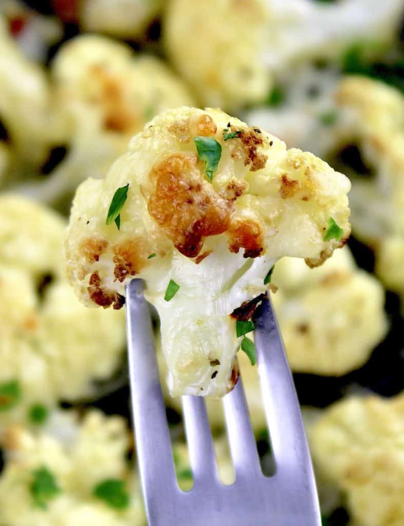 Cheesy Roasted Cauliflower floret held up with fork