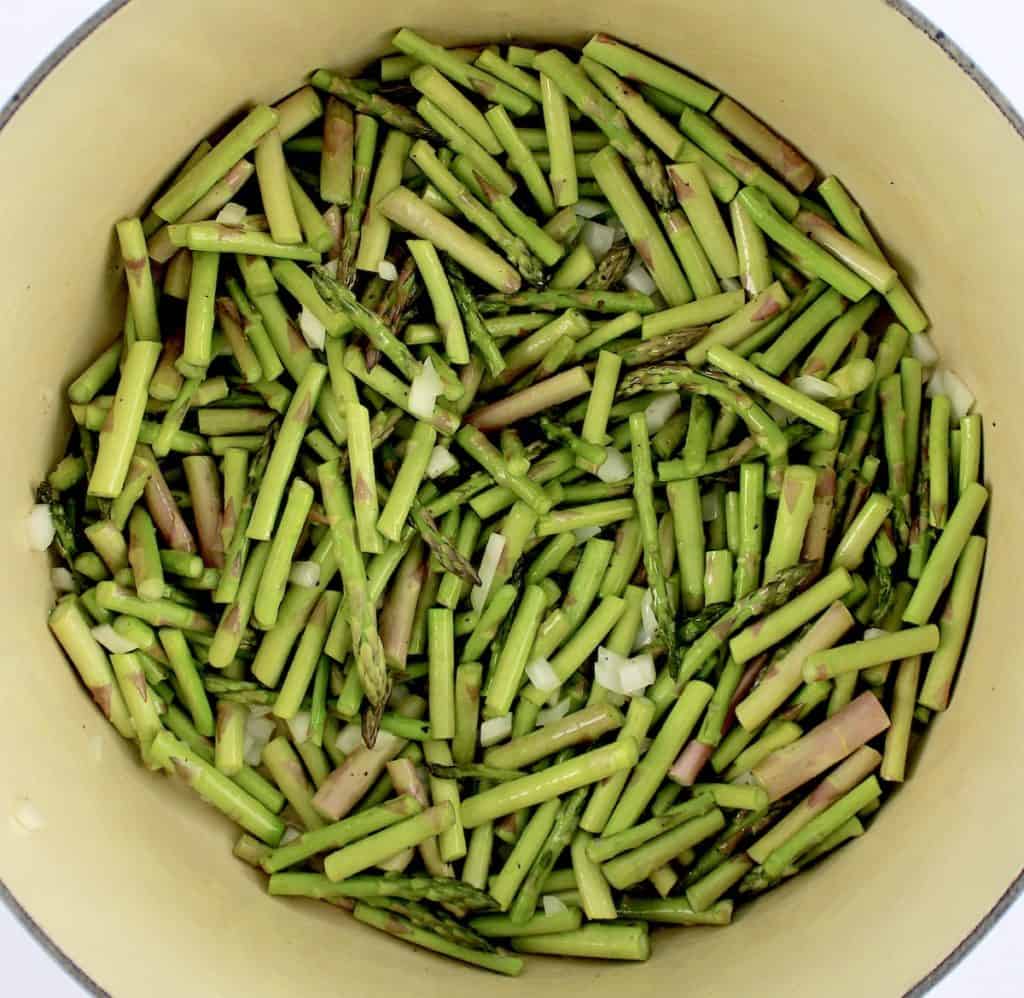 chopped asparagus and onions in pot