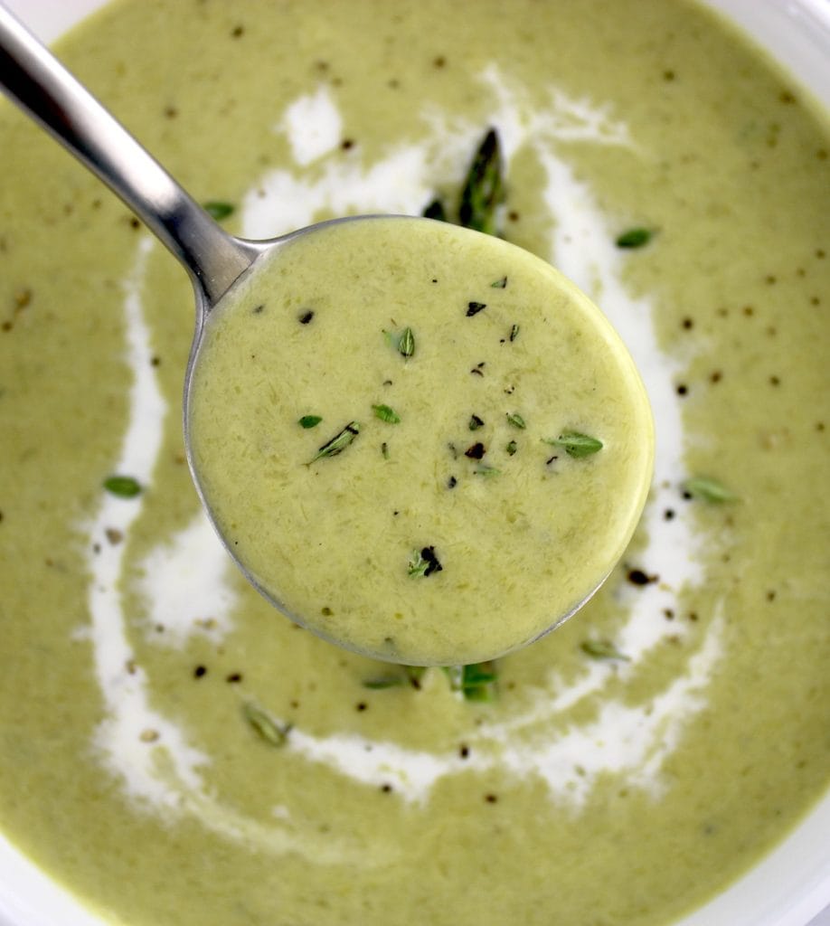 closeup of Cream of Asparagus Soup in spoon held up over soup