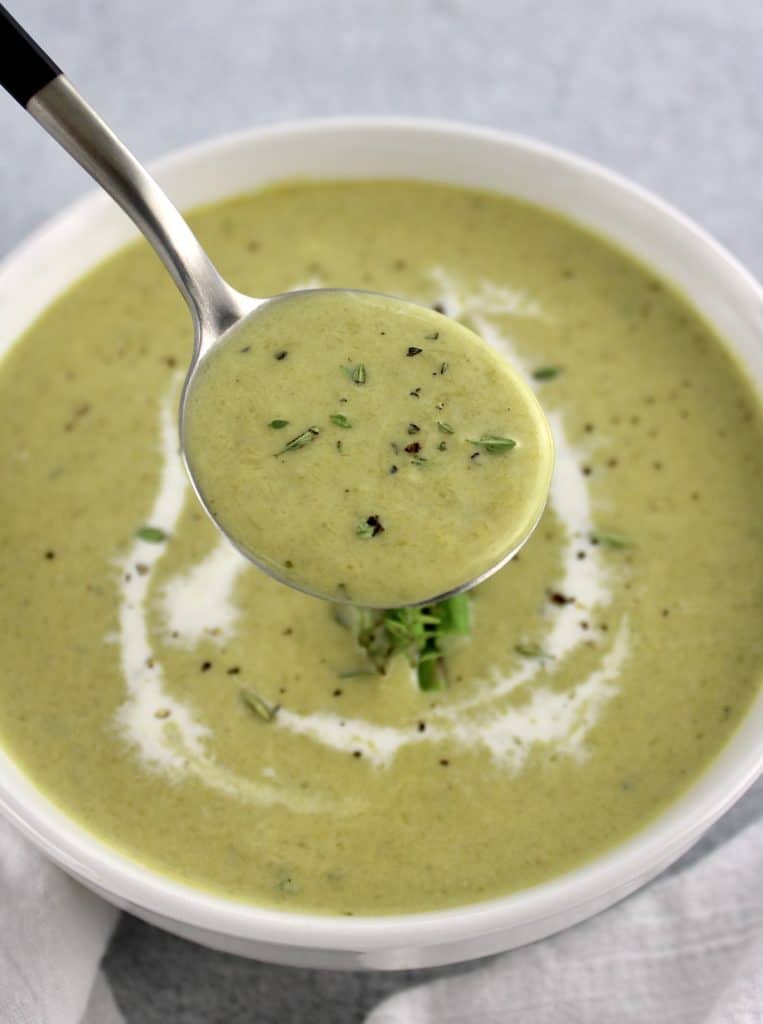 closeup of Cream of Asparagus Soup in spoon held up over soup