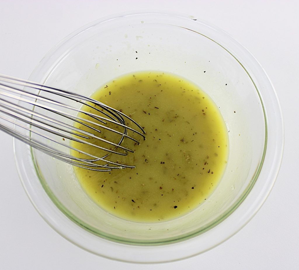 Easy Italian Pasta Salad dressing in glass bowl with whisk