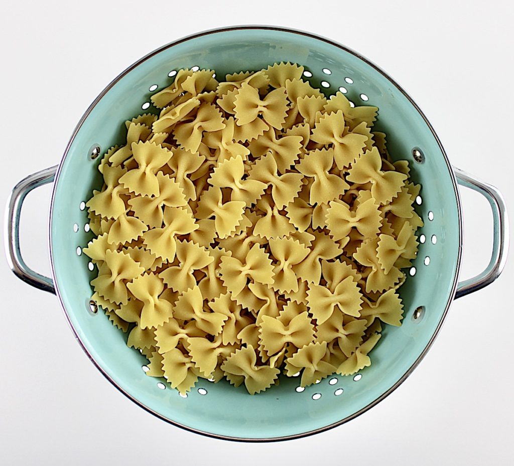 farfalle pasta in blue collander