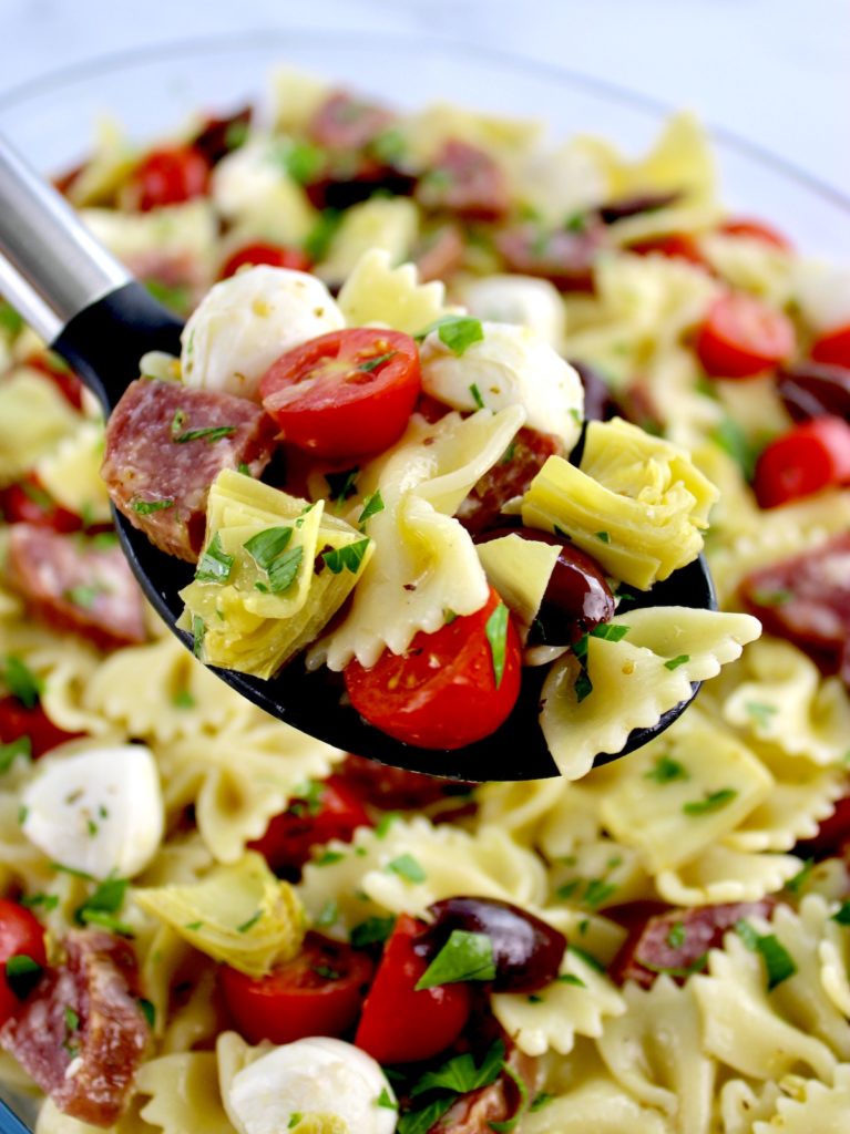 Easy Italian Pasta Salad with serving spoon holding up some