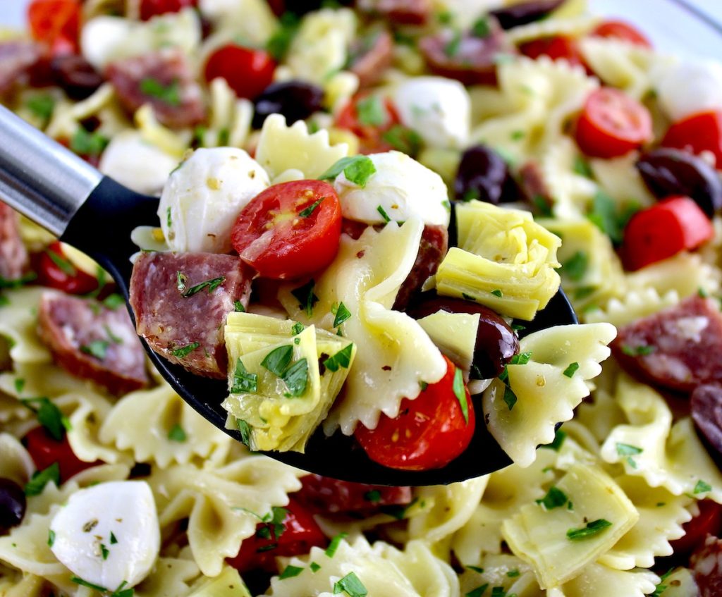 Easy Italian Pasta Salad with serving spoon holding up some