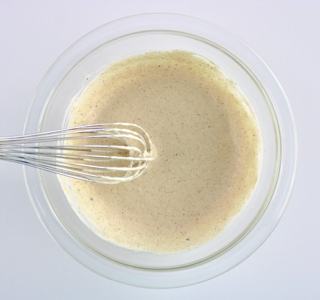 Egg Salad dressing in glass bowl with whisk