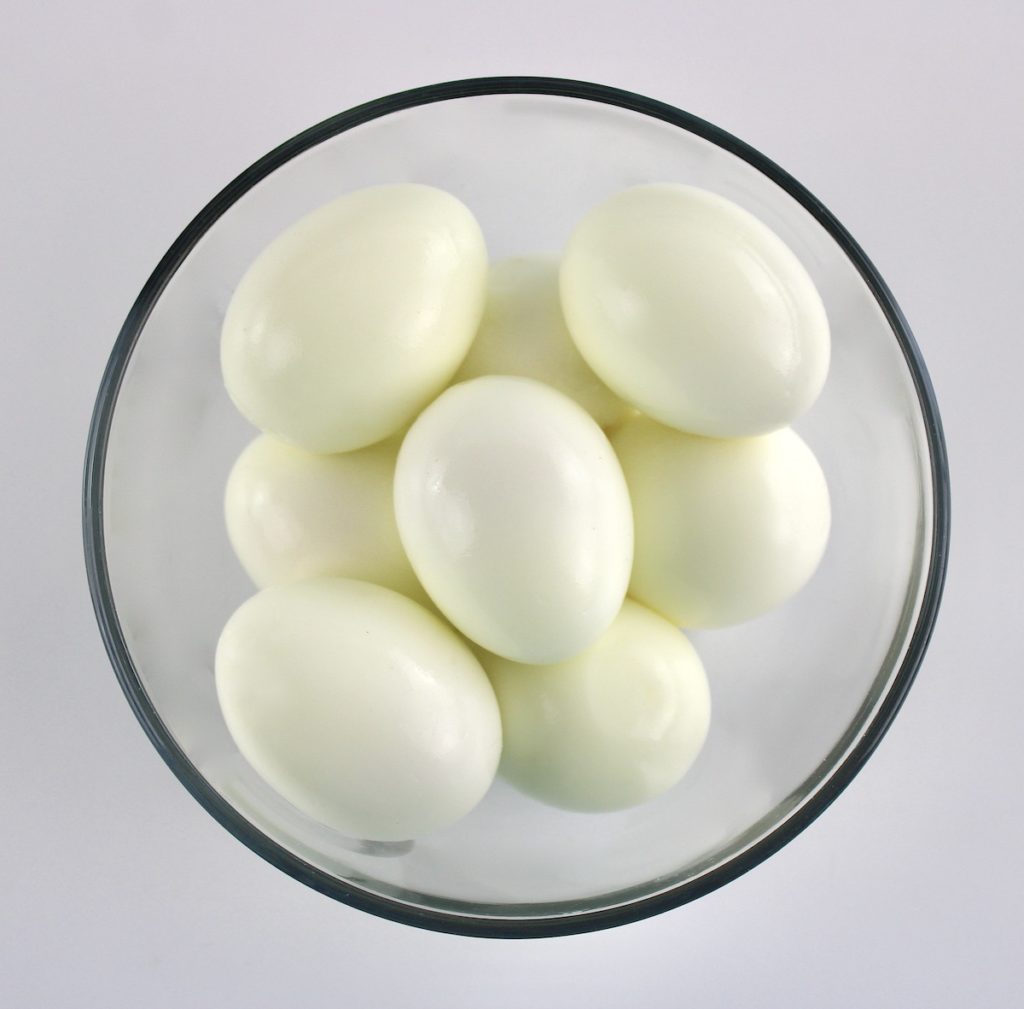 8 peeled hard boiled eggs in glass bowl