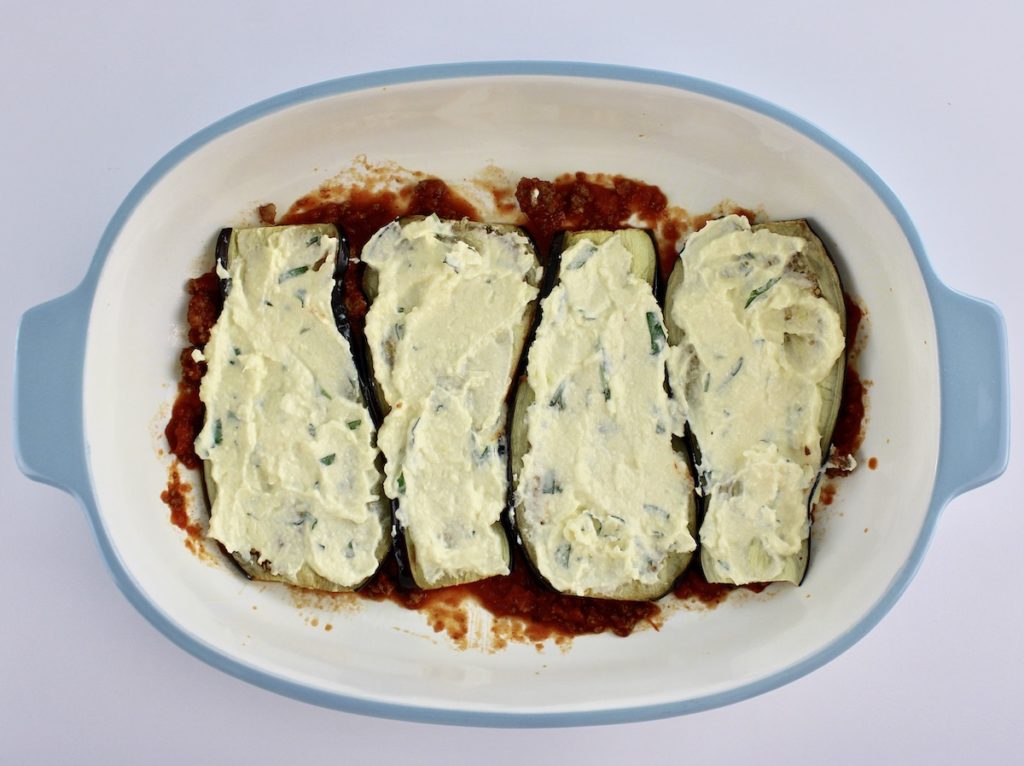 ricotta cheese mixture spread over 4 slices of eggplant in casserole