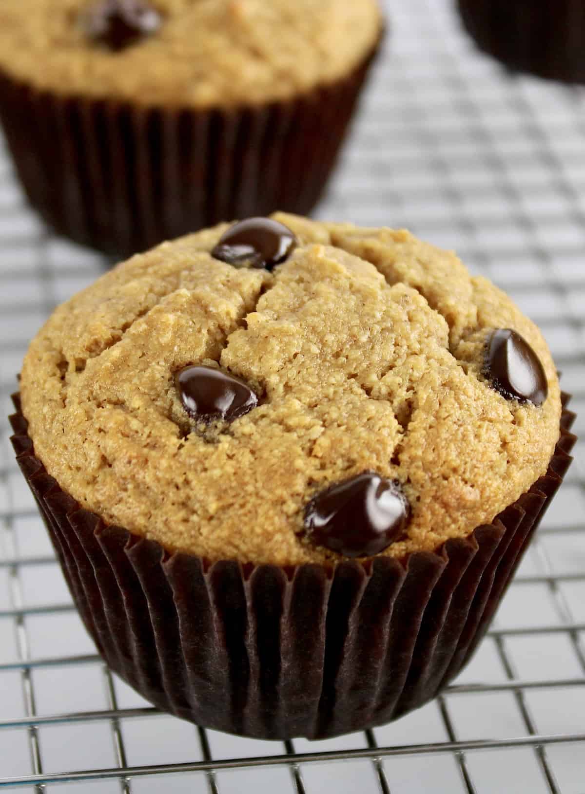 closeup of Gluten Free Banana Chocolate Chip Muffin in brown liner on cooking rack