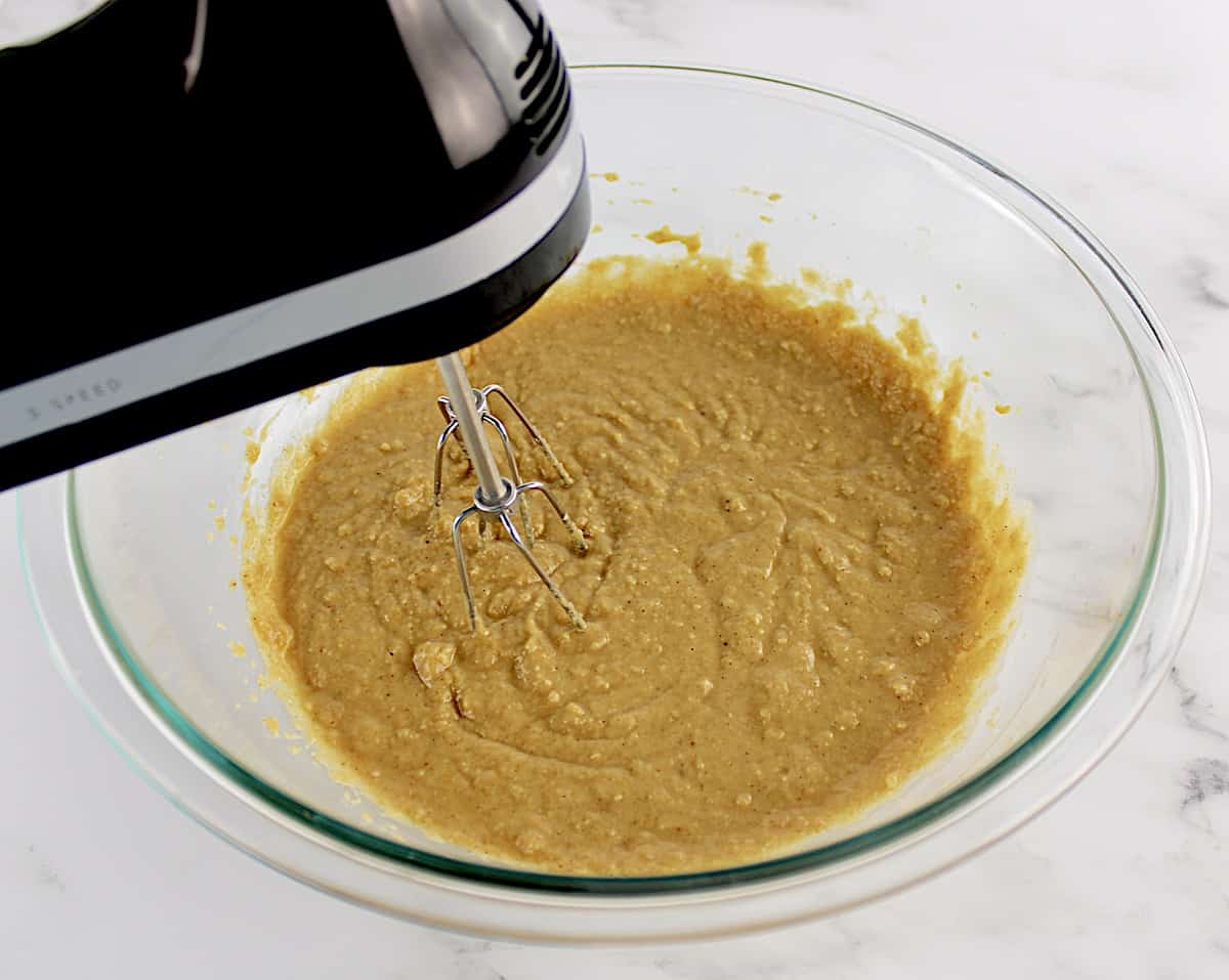 Gluten Free Banana Chocolate Chip Muffins batter being mixed with hand mixer in glass bowl